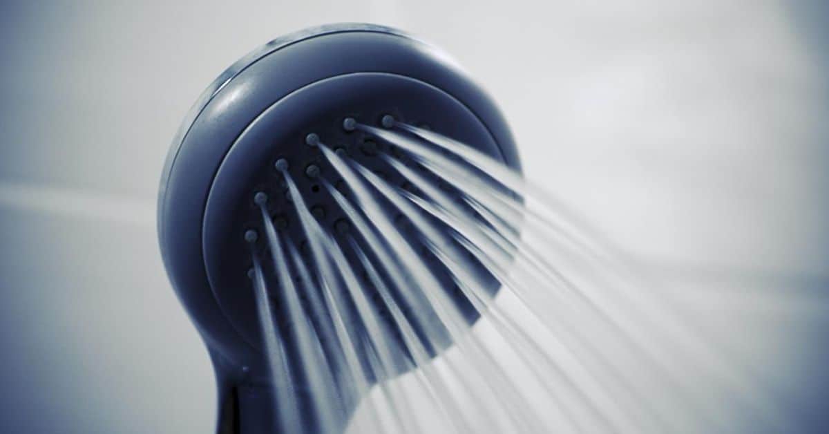 Blue plastic shower head spraying water